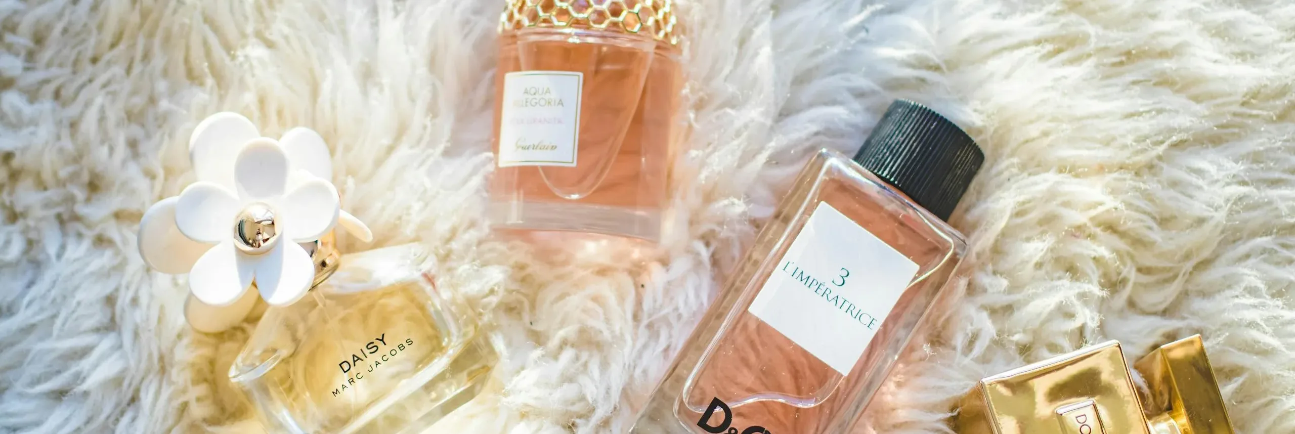 Elegant collection of perfume bottles on soft fur, highlighting luxury and style.